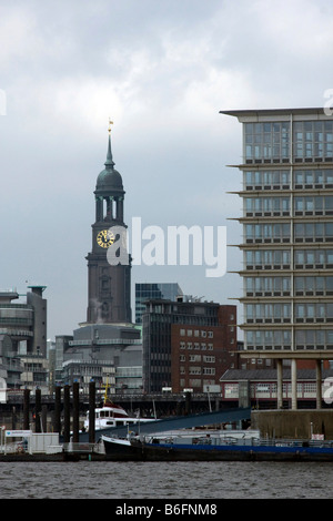 Steeple of St. Michaelis Church or Hamburger Michel, landmark of the city, seen from the port, behind the office buildings of G