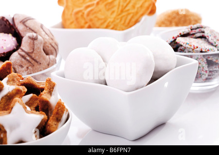Gingerbread biscuits in a white bowl and an assortment of christmas biscuits, cinnamon flavored star-shaped biscuits, chocolate Stock Photo