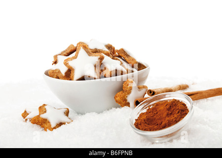 Cinnamon star-shaped biscuits and sticks of cinnamon in artificial snow Stock Photo