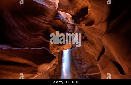 The noon sun casts a sun beam through the ceiling of the sandstone formations of Upper Antelope Canyon, Page, Arizona Stock Photo