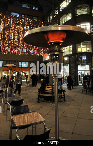London West End at Christmas time restaurants providing outdoor gas heater beside tables for eating out similar to so called garden patio heaters UK Stock Photo