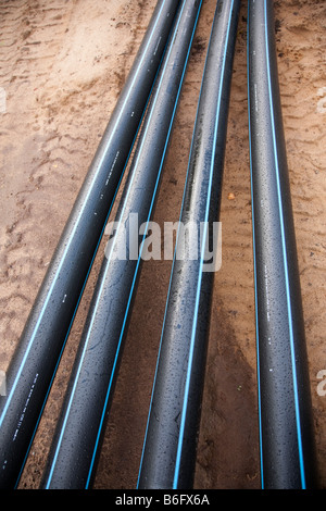 Black PVC water pipes laying on the ground Stock Photo