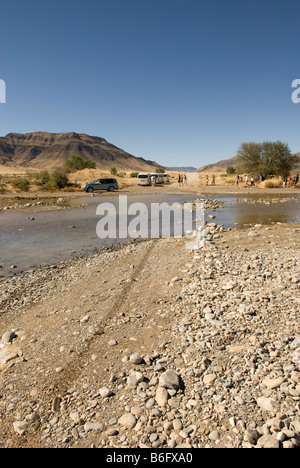 A swollen river floods the road and makes for difficult driving conditions on the D854 road in Namibia Stock Photo