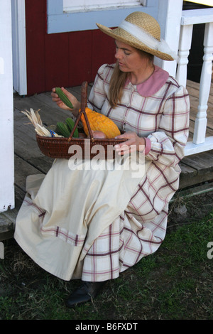 A lady going over her vegetables that she picked while sitting on the porch Stock Photo