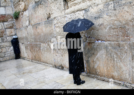 Religious Jews praying at the Western Wall in in the Old City of Jerusalem during a snow storm. Stock Photo