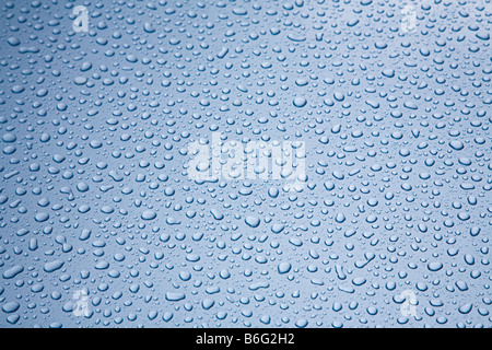 Raindrops on blue metal bonnet of classic car Stock Photo