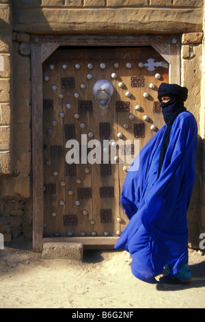 A Tuareg man standing by an old wooden door in Timbuktu Mali West Africa Stock Photo