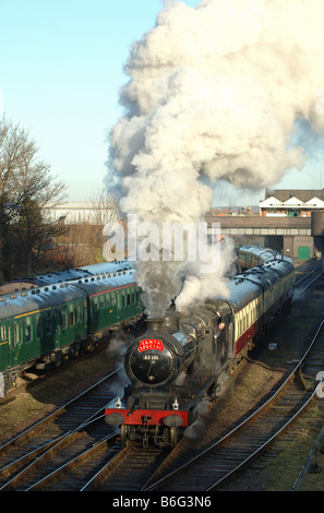 steam train departing Loughborough Central station on the Great Central Railway, Leicestershire, England, UK Stock Photo