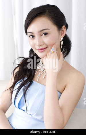 Young woman wearing a blue dress showing a ring on hand Stock Photo
