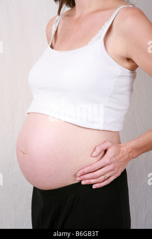 closeup-of-pregnant-womans-stomach-bump-at-12-weeks-3-months-gestation