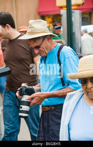 Tourist viewing digital image in back of camera on street Stock Photo