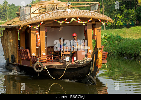 Traditional Kettuvallam houseboat plying canals with tourist in Backwaters of Kerala India Stock Photo