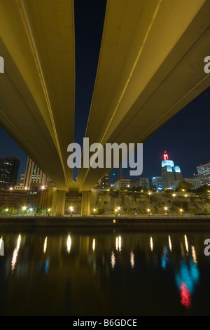 Seen from underneath the Wabasha St. bridge, the skyline of St. Paul, MN is reflected in the calm waters of the Mississippi. Stock Photo