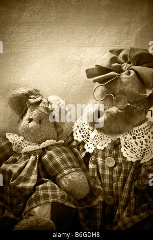 Old teddy bears sitting on a chair in soft light Stock Photo