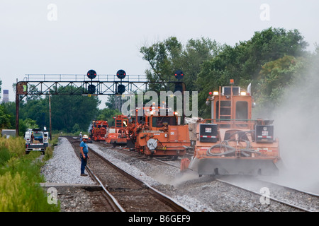 Railroad track maintenance machines go about their work on the Norfolk Southern main line in Indiana. Stock Photo