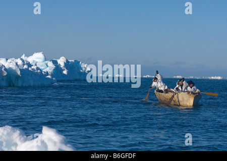 inupiaq whalers paddle an umiak through an open lead in the pack ice looking for bowhead whales Chukchi Sea Barrow Alaska Stock Photo