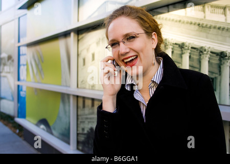 Business woman laughing while talking on mobile phone - USA Stock Photo