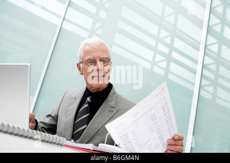 Older man working looking at papers Stock Photo