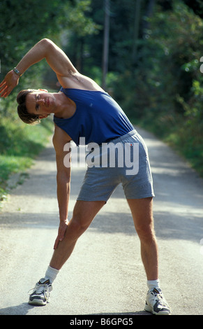 young man doing exercises out in countryside Stock Photo