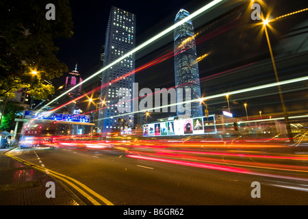 Central Hong Kong street at night with light trails from traffic and IFC in background Stock Photo