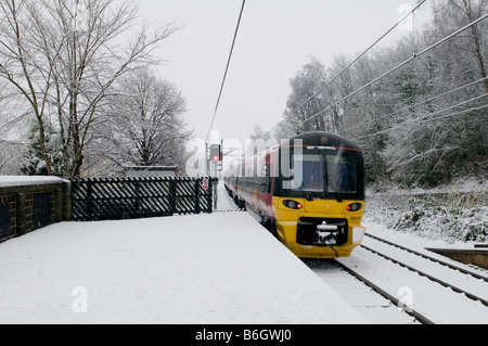 A morning train arrives at  the railway station after an overnight snowfall. Stock Photo