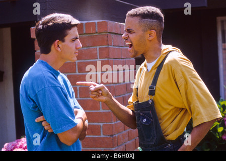 Angry black teen shouts at white boy. Stock Photo