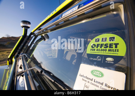 A carbon offset sticker on the windscreen of a mountain rescue landrover Stock Photo