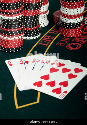 A winning poker hand on a card table with poker chips in the background Stock Photo