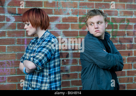 Couple man and woman having an argument standing back to back not speaking to each other Stock Photo