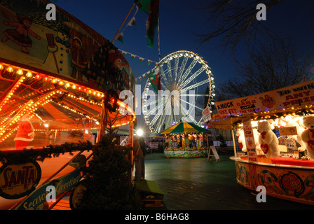 Cardiff Winter Wonderland's carousels and funfair in front of the 'Admiral Eye' Stock Photo