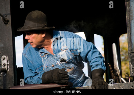 Train engineer looking out of cab on Old fashioned vintage locomotive train engine Stock Photo