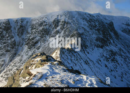 Looking along a wintry Striding Edge towards the summit of Helvellyn, North East Lake District Stock Photo