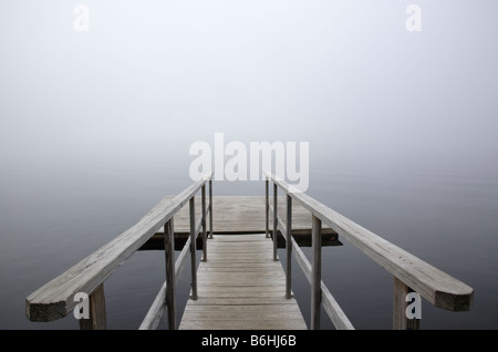 A dock on the Connecticut River in foggy conditions Located in Waterford Vermont USA which is part of New England Stock Photo