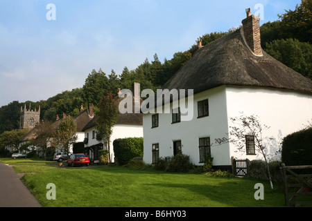 Row of white-washed thatched cottages line the main street through the Dorset village of Milton Abbas Stock Photo