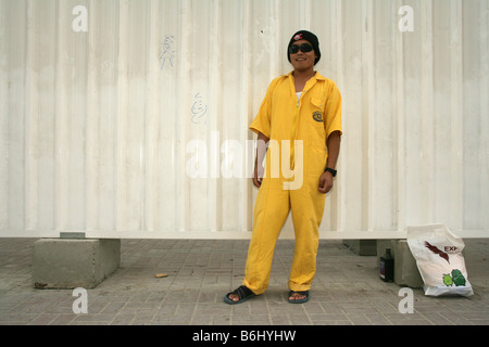 Migrant construction worker on construction site wearing sunglasses and yellow boilersuit, portrait, Doha, Qatar, Middle East Stock Photo