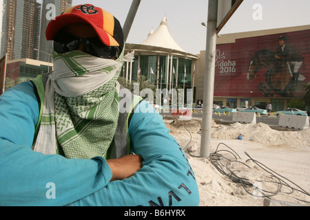 Migrant construction worker on construction site wearing sunglasses and scarf covering face, Doha, Qatar, Middle East Stock Photo