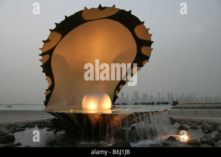 Oyster pearl sculpture and water fountain with waterfront city skyline, Corniche, Doha, Qatar, Middle East Stock Photo
