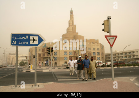 Men crossing the street in front of the Kassem Darwish Fakhroo Islamic Centre in Doha, Qatar. Stock Photo