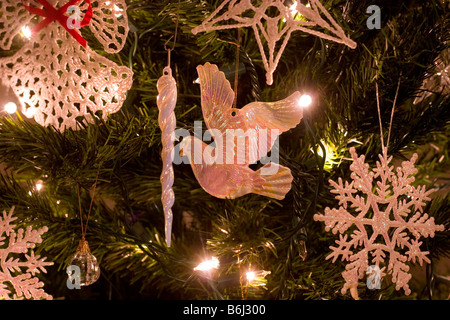 Christmas dove, icicle, star, and snow flake ornaments made of glass, crystal and wool hanging on a tree indoors Stock Photo