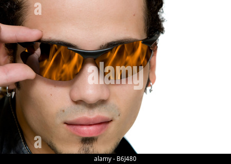 close up portrait of a young guy wearing eyeglasses with a fire reflection Stock Photo