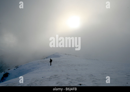 Fellwalking in the cloud on Helvellyn's snow covered summit plateau, North East Lake District