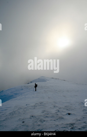 Fellwalking in the cloud on Helvellyn's snow covered summit plateau, North East Lake District Stock Photo