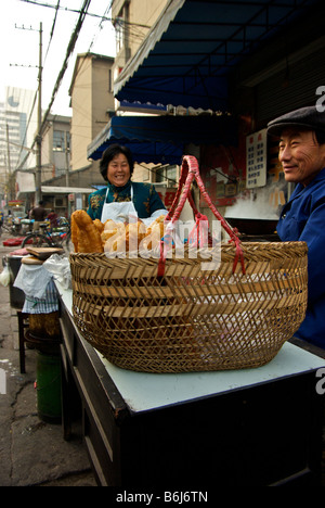 Happy vendor couple selling deep fried Chinese bread stick breafast and other foods Stock Photo