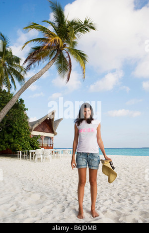 A young woman posing for a photograph on an empty beach in The Maldives Stock Photo