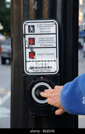 Pedestrian crossing control button being activated by pushing a button Stock Photo