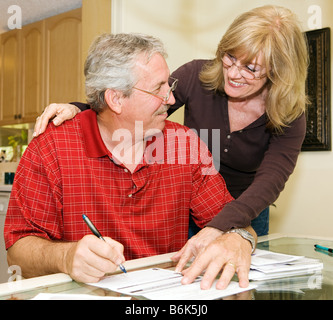 Mature couple happy about paying off their debts Stock Photo