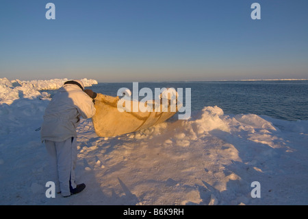 Inupiaq whalers with a seal skin boat or umiak waits and watches for passing bowhead whales Stock Photo