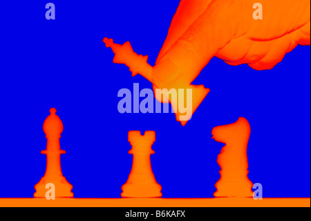 male hand moving chess pieces silhouetted on chess board digitally altered Stock Photo