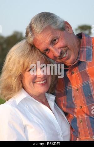 a very attractive married couple posing for a portrait in the late afternoon sun Stock Photo
