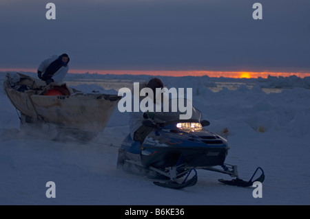 Inupiaq subsistence whalers haul their seal skin boat or umiak away from an open lead in the pack ice Chukchi Sea outside Stock Photo